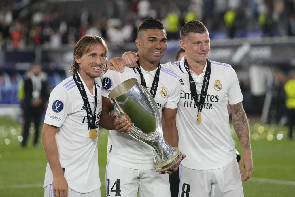 Na archívnej snímke z 10. augusta 2022 futbalisti Realu Madrid zľava Luka Modrič, Casemiro a Toni Kroos pózujú s trofejou po triumfe v zápase o európsky Superpohár UEFA Real Madrid - Eintracht Frankfurt na Olympijskom štadióne v Helsinkách.
