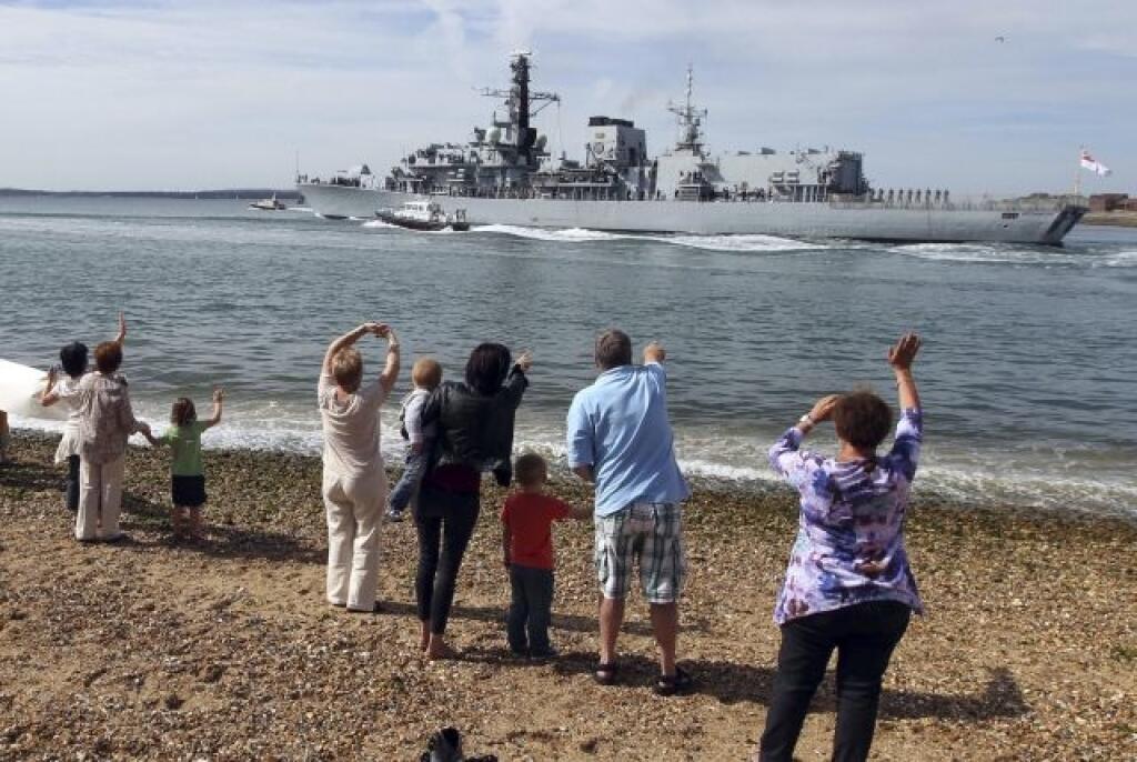 People wave from the beach as Britain's Royal Navy ship HMS Westminster sets sail from Portsmouth, England, for Gibraltar en route to pre-planned international training exercise Cougar in the Mediterranean and Gulf Tuesday Aug. 13, 2013. The British government said Monday it is considering taking Spain to court if it does not ease border checks on traffic entering the disputed enclave of Gibraltar. Spain has long laid claim to Gibraltar, and the tiny territory on the southern tip of the Iberian
