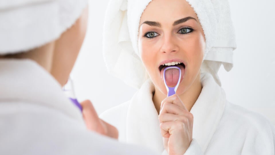 Close-up,Of,A,Woman,Looking,In,Mirror,Cleaning,Her,Tongue