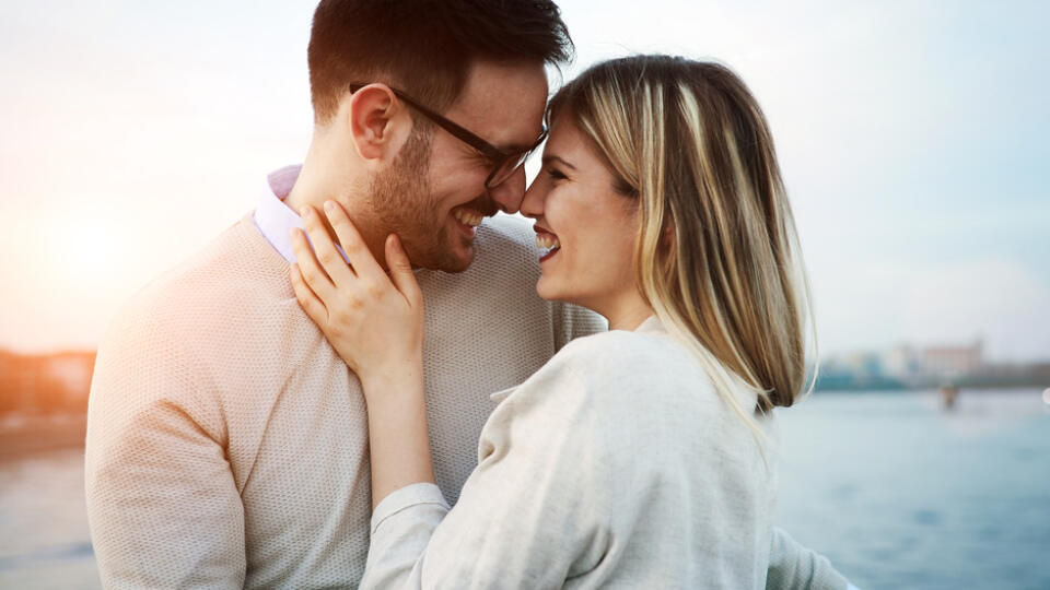 Couple,Kissing,Dating,On,Bridge,During,Sunset