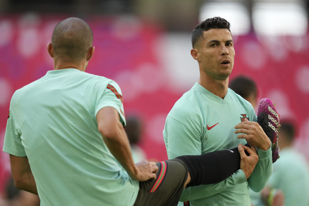 KK8 Mníchov - Portugalskí futbalisti Cristiano Ronaldo a Pepe počas tréningu portugalskej futbalovej reprezentácie na ME vo futbale 18. júna 2021 v Mníchove. Portugalsko odohrá v sobotu zápas skupiny F proti Nemecku. FOTO TASR/AP
Portugal's Cristiano Ronaldo strechtes next to team mate Pepe during a training session at the football arena stadium in Munich, Friday, June 18, 2021 the day before the Euro 2020 soccer championship group F match between Portugal and Germany. (AP Photo/Matthias Schrade
