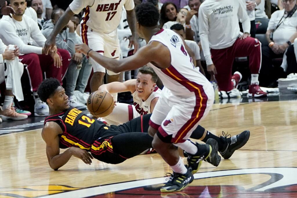 PK 96 Miami - Na snímke zľava De'Andre Hunter (Atlanta), Duncan Robinson a Kyle Lowry (obaja Miami) bojujú o loptu počas zápasu zámorskej basketbalovej NBA Miami Heat - Atlanta Hawks v Miami v nedeľu 17. apríla 2022. FOTO TASR/AP
Atlanta Hawks forward De'Andre Hunter (12) and Miami Heat guard Duncan Robinson go for a loose ball during the first half of Game 1 of an NBA basketball first-round playoff series, Sunday, April 17, 2022, in Miami. (AP Photo/Lynne Sladky)