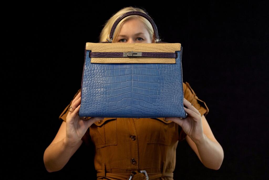 EBE 18 Londýn - Zamestnankyňa spoločnosti Bonhams predvádza kabelku módnej značky Hermès špeciálnej edície Tri-Color Alligator Retourne Kelly 35 v aukčnom dome v Londýne v stredu 6. októbra 2021. Jej cena sa odhaduje na 30 000 - 40 000 britských libier a bude vydražená v aukcii v Bonhams v Londýne 12. októbra 2021. FOTO TASR/AP
A Bonhams employee displays a Special Order Tri-Colour Alligator Retourne Kelly 35, Hermes, 2011 handbag in London, Wednesday, Oct. 6, 2021. The handbag estimated at 30,