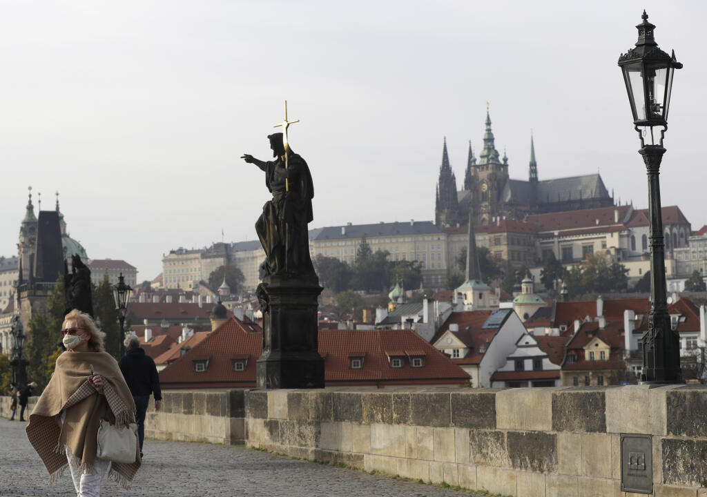 EBE 28 Praha - Na snímke žena s ochranným rúškom prechádza po poloprázdnom Karlovom moste v Prahe v Českej republike v stredu 21. októbra 2020. Česká vláda pristúpila v stredu k ďalším opatreniam v boji proti pandémii koronavírusu SARS-CoV-2. Od štvrtka od 6.00 h bude uzavretý maloobchod. Výnimku majú predajne základného sortimentu. Veľkoobchod bude bez obmedzenia. Vláda od štvrtka nariadila aj obmedzenie pohybu a kontaktu s ľuďmi s výnimkou ciest do práce a na nákupy. Pohyb v prírode bude možný