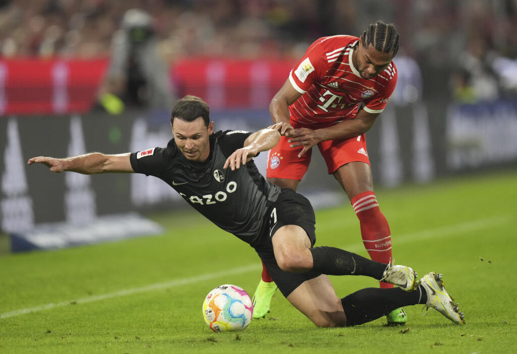 PK 95 Mníchov - Na snímke sprava futbalista Bayernu Serge Gnabry a Nicolas Höfler z Freiburgu bojujú o loptu v zápase 11. kola nemeckej Bundesligy Bayern Mníchov - SC Freiburg v Mníchove 16. októbra 2022. FOTO TASR/AP
Bayern's Serge Gnabry, right, challenges for the ball with Freiburg's Nicolas Hoefler during the German Bundesliga soccer match between FC Bayern Munich and SC Freiburg at the Allianz Arena in Munich, Germany, Oct. 16, 2022. (AP Photo/Matthias Schrader)