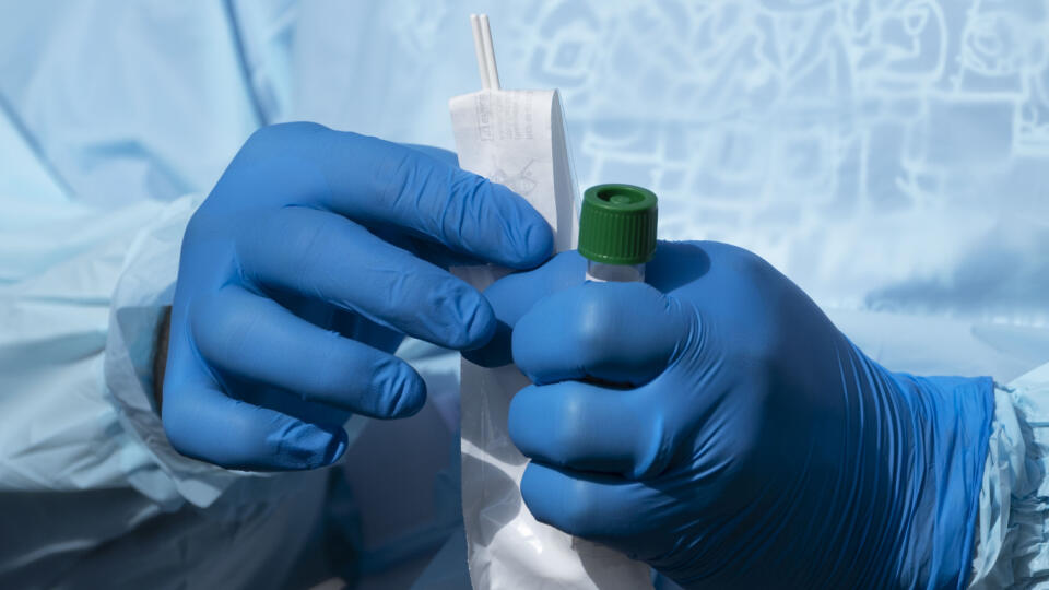 Zdravotník drží v rukách tampóny a skúmavky určené na testovanie ľudí na chorobu COVID-19 vo West Palm Beach, v USA.