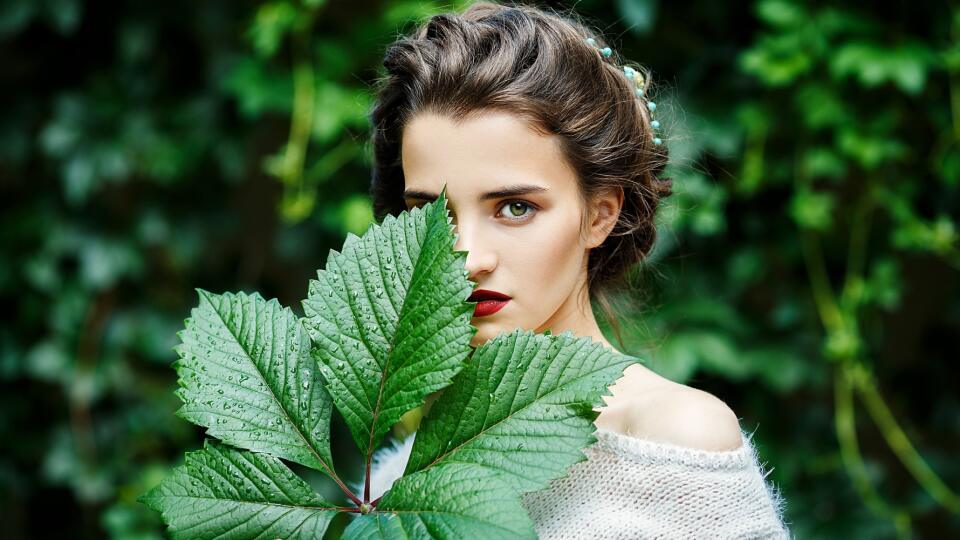 Portreit of young girl with grape leaf in her hand