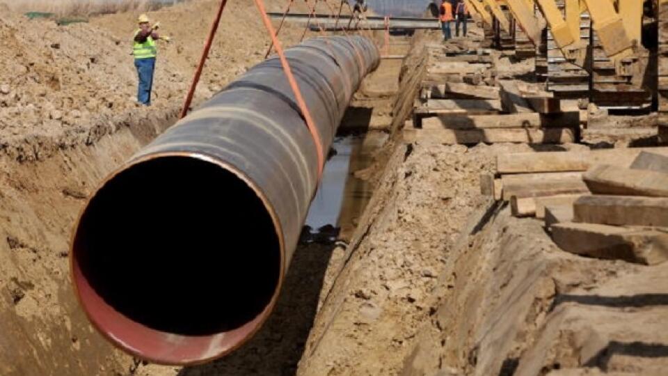LUBMIN, GERMANY - APRIL 08: A worker shouts commands as cranes lower a section of pipe into the ground for the OPAL pipeline on April 8, 2010 near Lubmin, Germany. The OPAL and NEL pipelines will carry natural gas from Russia arriving through the Nord Stream pipeline from the Baltic Sea across Germany and to other countries in Europe. The Nord Stream project delivers Russian natural gas directly to western Europe and avoids countries in between, such as Poland and Ukraine. (Photo by Sean Gallu