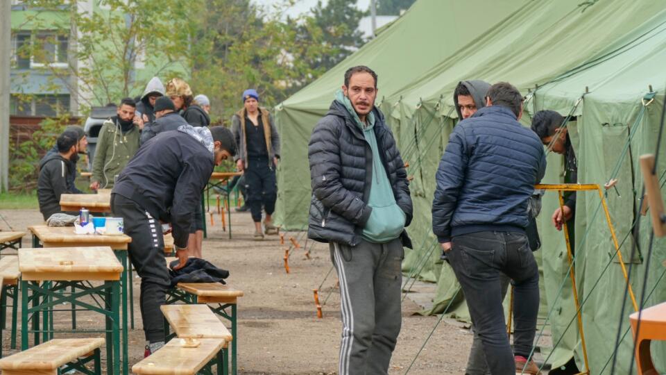 V strede stanového tábora sú stoly a lavice, aby sa utečenci mali kde najesť.