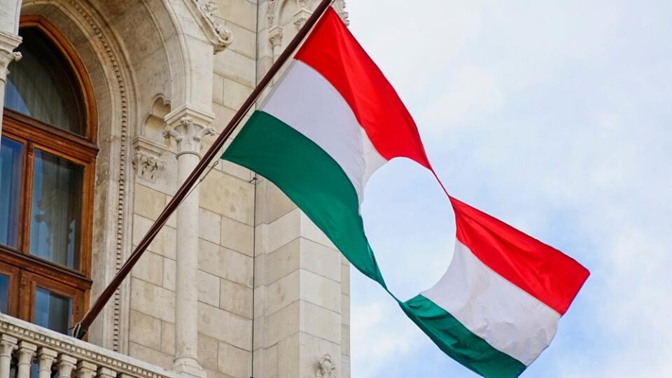 Hungarian,Flag,With,A,Hole,Before,The,Parliament,In,Budapest,