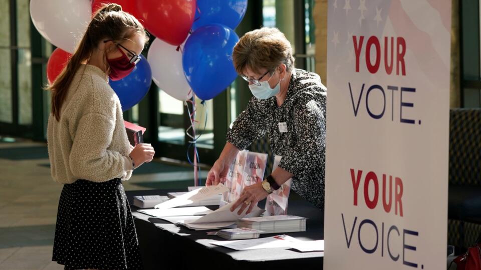 During a break between morning church services, Beverly Sides, right, with the Prestonwood Cultural Impact Team shows Suzie Brewer election voter guides for various north Texas counties at Prestonwood Baptist Church Sunday, Oct. 11, 2020, in Plano, Texas. Evangelical churches and their suburban members are a key to President Trump's voter support in Texas.