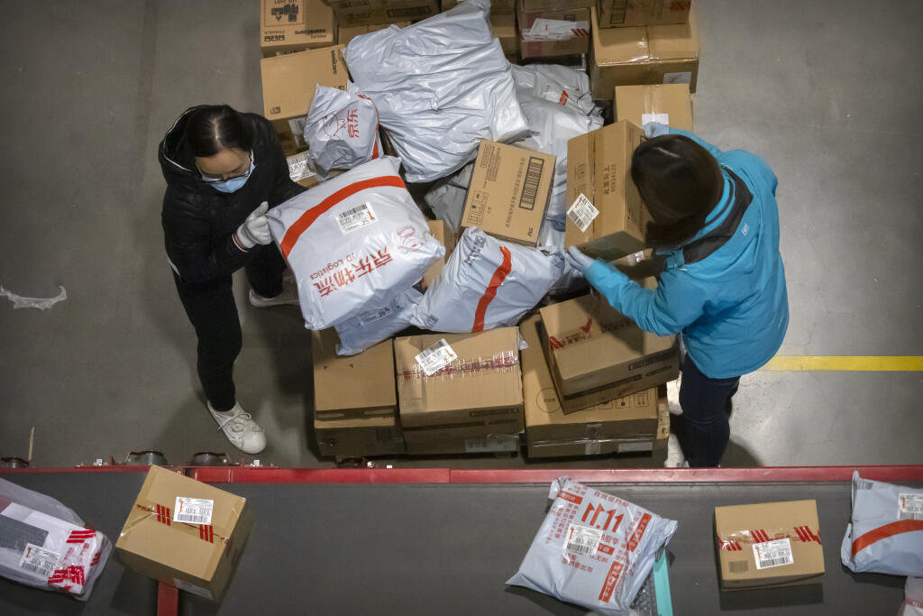 WA 9 Peking - Zamestnanci nakladajú balíky na pás v sklade pre čínskeho internetového predajcu JD.com v Pekingu v stredu 11. novembra 2020. Očakáva sa, že čínski spotrebitelia počas tzv. Sigles' Day (Dňa nezadaných), ktorý je najrušnejším on-line nákupným dňom na svete,  utratia desiatky miliárd za nákup od čerstvých potravín až po luxusný tovar v čase, keď sa krajina spamätáva z pandémie koronavírusu. Singles' Day vytvorili v 90. rokoch minulého storočia čínski študenti vysokých škôl ako altern