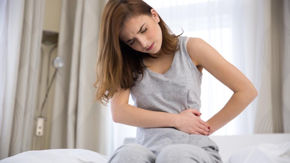 woman sitting on the bed with pain