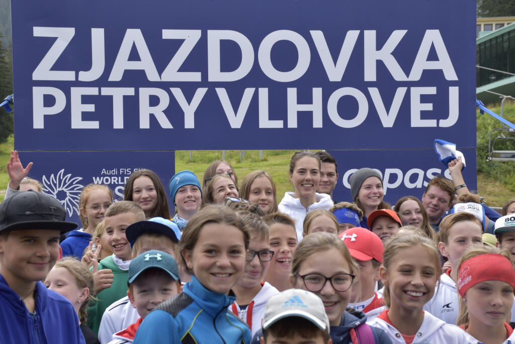 V horskom stredisku Jasná - Nízke Tatry odštartovali novú tradíciu známu zo zahraničia - zjazdovka č. 1, doteraz známa ako Pretekárska, bude po novom niesť meno celkovej víťazky Svetového pohára v alpskom lyžovaní Petry Vlhovej. Tá na nej začiatkom marca vyhrala preteky Svetového pohára v obrovskom slalome. Na snímke vzadu uprostred lyžiarka Petra Vlhová s mladými nádejnými lyžiarmi a deťmi počas slávnostného odhalenia zjazdovky Petry Vlhovej. V Demänovskej doline, 18. augusta 2021. FOTO TASR -
