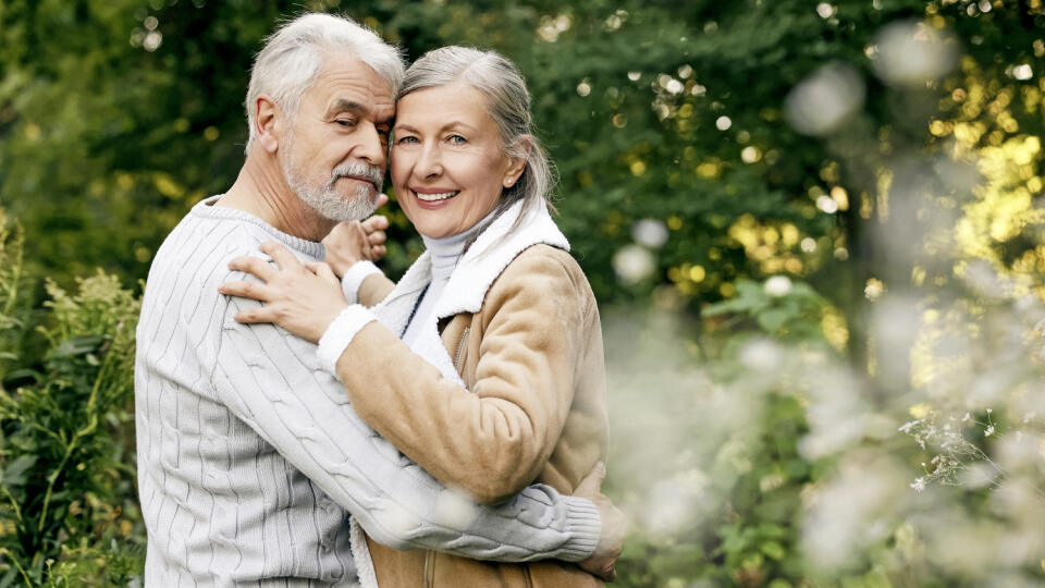 Affectionate senior couple dancing together outdoors, space for text