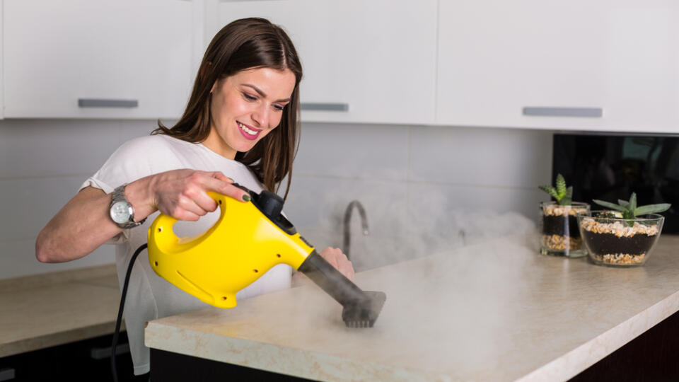 Young,Beautiful,Woman,Cleaning,Kitchen,With,Steam,Cleaner