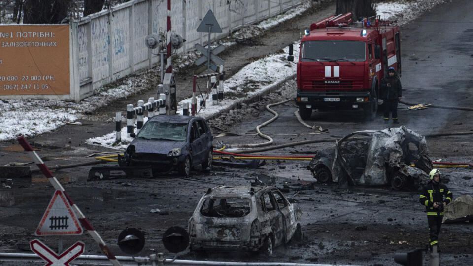 Hasič kráča okolo vrakov áut po ruskom raketovom útoku v Kyjeve v stredu 23. novembra 2022.