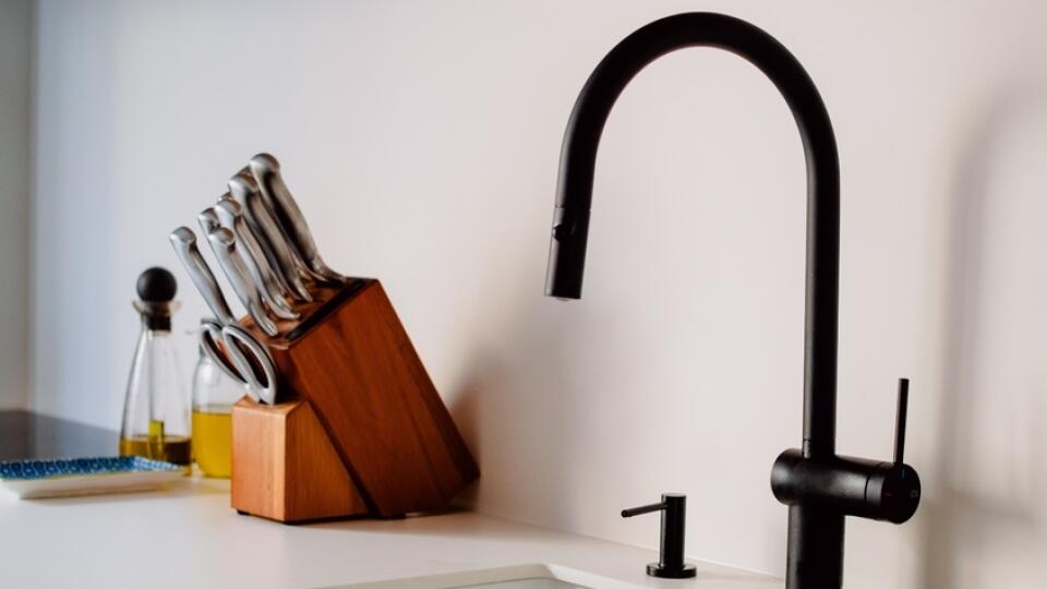 A,Sink,With,A,Black,Faucet,And,A,Knife,Block