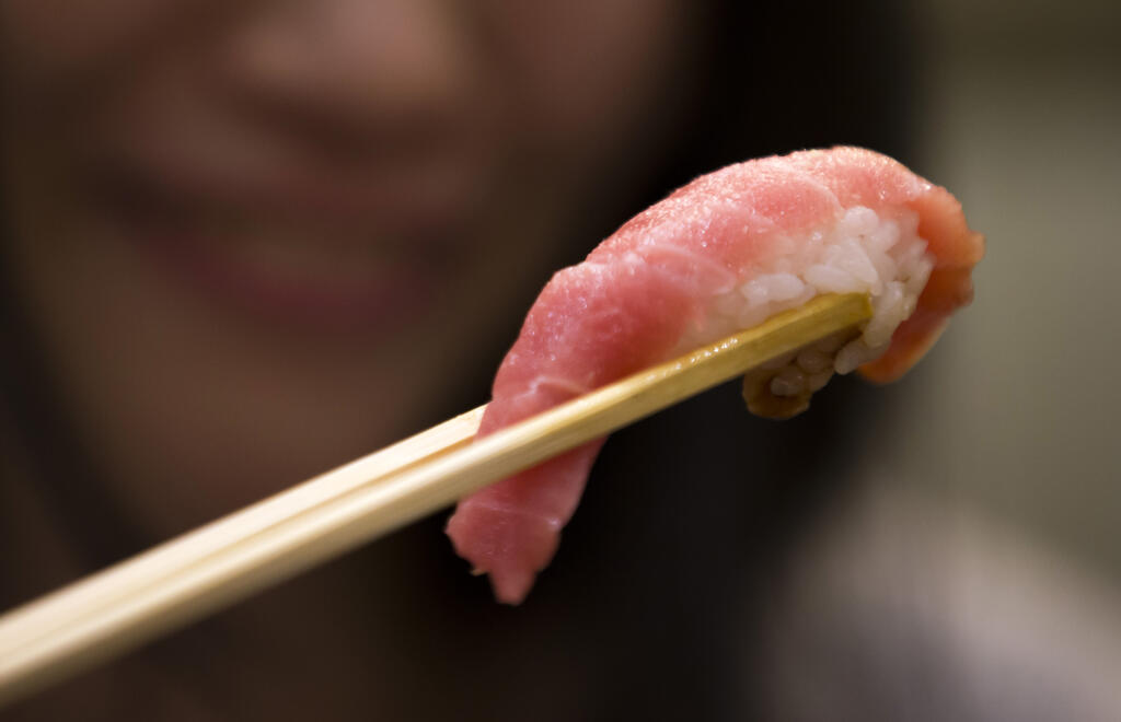 TOKYO, JAPAN - JANUARY 05:  A customer eats a piece of tuna sushi inside  one of the company's Sushi Zanmai sushi restaurants after the year's first auction at Tsukiji Market on January 5, 2017 in Tokyo, Japan. Kiyomura Co. bid the highest priced tuna weighing 212 kilogram (467.38 pound) for 74.2 million yen ($637,155) at the year's first auction.  (Photo by Tomohiro Ohsumi/Getty Images)