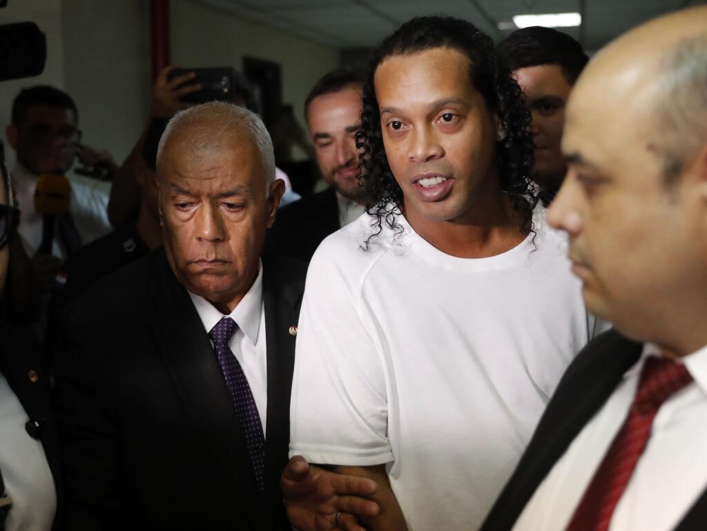 EBE 9 Asución - Na snímke uprostred bývalého brazílskeho futbalistu Ronaldinha odvádza paraguajská polícia na súd v Asuncióne 6. marca 2020. FOTO TASR/AP
Former soccer star Ronaldinho is escorted by police to go before Judge Mirko Valinotti at the Justice Palace court in Asuncion, Paraguay, Friday, March 6, 2020. Ronaldinho has been detained by Paraguayan police for allegedly entering the country with a falsified passport. (AP Photo/Jorge Saenz)