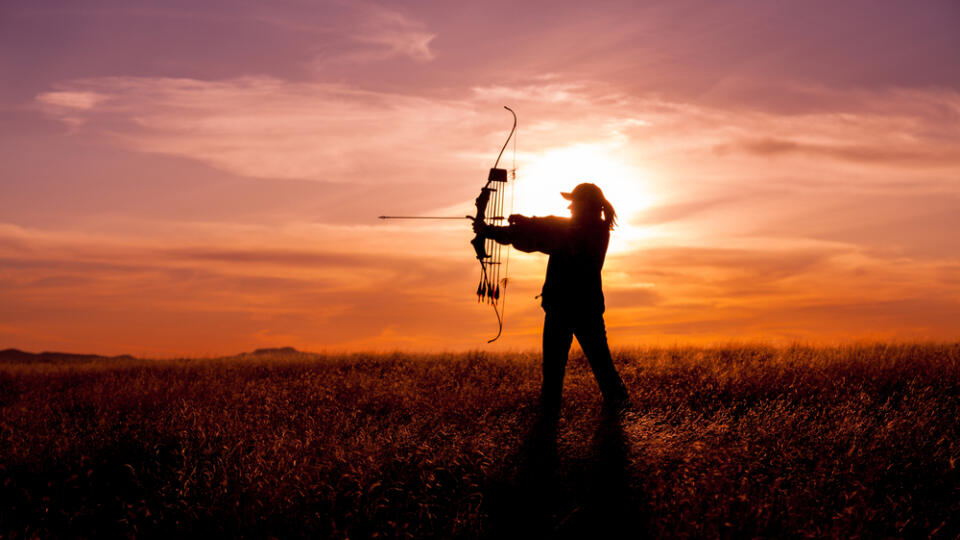 Female,Bowhunter,At,Sunset