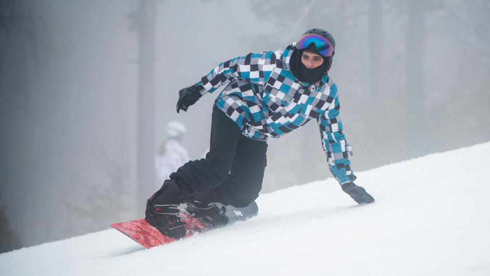 Na snímke návštevník sa snowboarduje počas hustej hmly v lyžiarskom areáli Ski Lysá 26. decembra 2022. FOTO TASR - Veronika Mihaliková