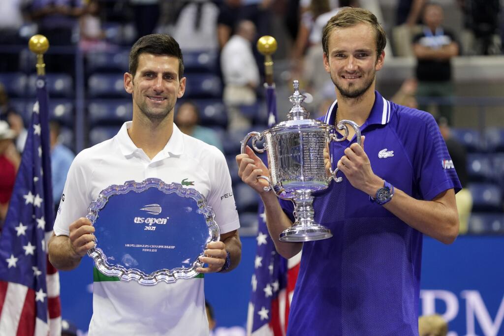 KK9 New York - Ruský tenista Daniil Medvedev (vpravo) pózuje s trofejou po víťazstve nad Srbom Novakom Djokovičom (vľavo) vo finále mužskej dvojhry na grandslamovom turnaji US Open 12. septembra 2021 v New Yorku. Ruský tenista Daniil Medvedev sa stal víťazom mužskej dvojhry na US Open a získal prvý grandslamový titul v kariére. Vo finále zvíťazil po životnom výkone ako nasadená dvojka nad turnajovou jednotkou Srbom Novakom Djokovičom 6:4, 6:4, 6:4 a prekazil mu kalendárny Grand Slam. FOTO TASR/A