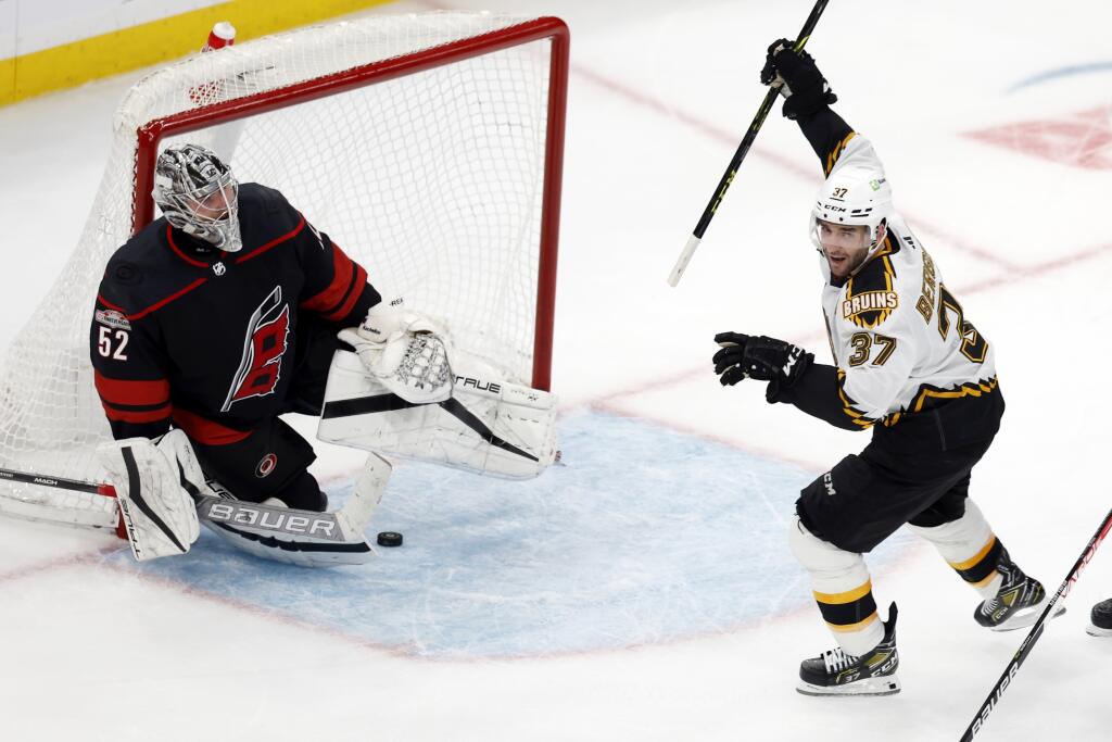 Kapitán Bostonu Bruins Patrice Bergeron sa teší z gólu, ktorý strelil jeho spoluhráč David Pastrňák predĺžení zápasu zámorskej hokejovej NHL Boston Bruins - Carolina Hurricanes v Bostone v piatok 25. novembra 2022.