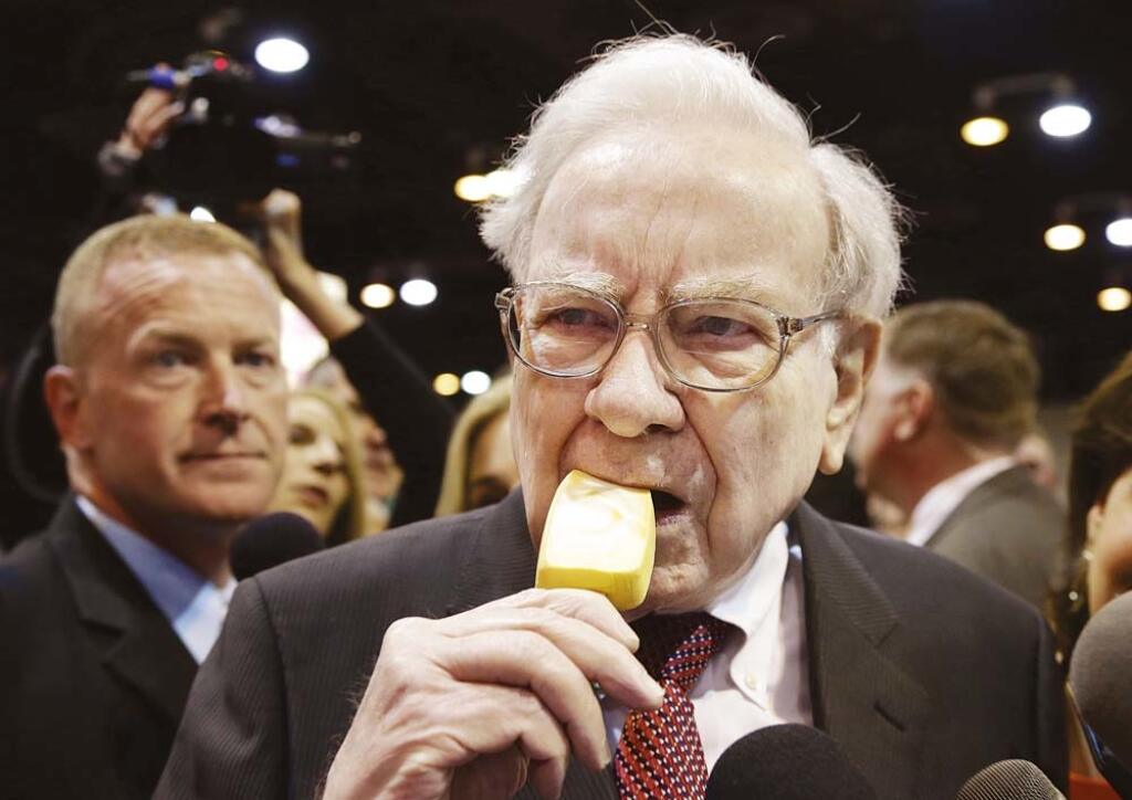 Berkshire Hathaway Chairman and CEO Warren Buffett eats an ice cream bar while touring the exhibition floor prior to the annual shareholders meeting on Saturday, May 3, 2014, in Omaha, Neb. More than 30,000 shareholders are expected to fill the CenturyLink Arena to hear Buffett and Berkshire Vice Chairman Charlie Munger discuss their business. (AP Photo/Nati Harnik)