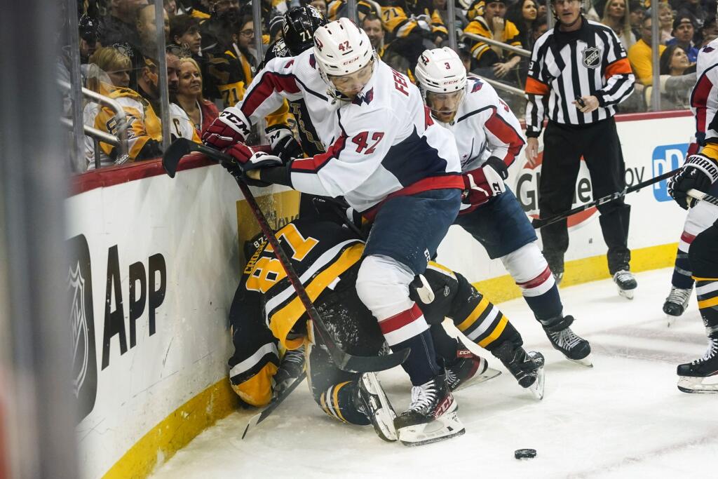 WA 28 Pittsburgh - Slovenský hokejista v drese Washingtonu Capitals Martin Fehérváry (42) a kapitán Pittsburghu Penguins Sidney Crosby (87) bojujú o puk pri mantineli počas zápasu zámorskej hokejovej NHL Pittsburgh Penguins - Washington Capitals v Pittsburghu v sobotu 9. apríla 2022. FOTO TASR/AP
Pittsburgh Penguins' Sidney Crosby (87) is pinned against the boards by Washington Capitals' Martin Fehervary (42) and Nick Jensen (3) during the second period of an NHL hockey game, Saturday, April 9