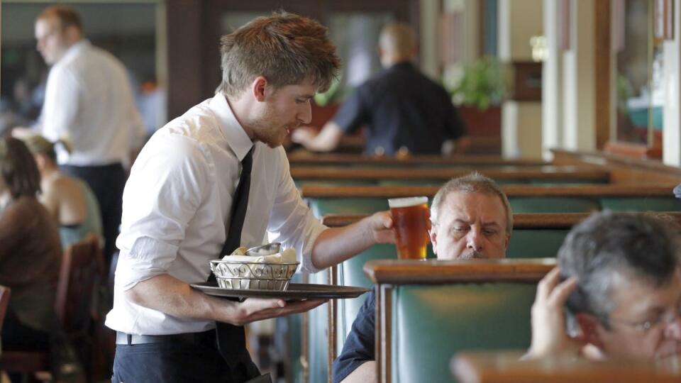 Waiter Spencer Meline serves a customer at Ivar's Acres of Clams restaurant on the Seattle waterfront Wednesday, May 14, 2014. While the Seattle mayor is proposing to raise the minimum wage to $15 in the coming years to the highest level in the nation, some activists say that's too slow and are threatening to take the issue to voters with a ballot measure that would force a raise sooner. As the mayor's plan is being debated by the council, businesses are sounding the alarm that raising the wage