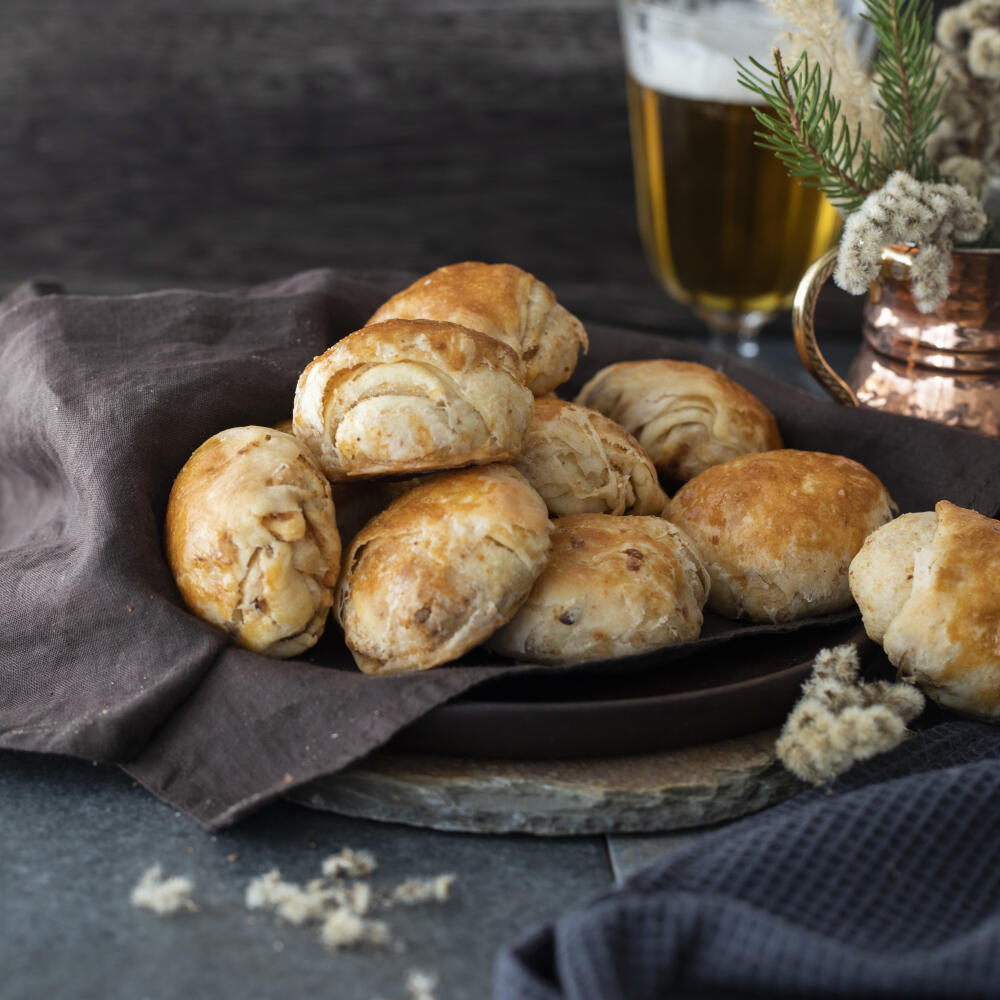 oškvarkové pagáče
recept:
30 KÚSKOV, PRÍPRAVA 30 MINÚT, KYSNUTIE 90 MINÚT, PEČENIE 15 MINÚT
• 200 ml mlieka
• 1 lyžička kryštálového cukru
• 25 g čerstvého droždia
• 500 g hladkej múky (plus
na pomúčenie dosky)
• 1 lyžička soli
• 200 g oškvarkov
• 2 žĺtky na potretie
1. Do vlažného mlieka zamiešajte cukor
a nadrvte droždie. Nechajte vzísť kvások. 2. Potom preosejte múku, pridajte kvások
a soľ. Dlhším miesením vypracujte hladké, elastické cesto. Podľa potre