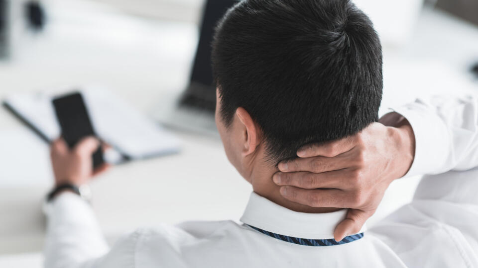 Back,View,Of,Businessman,Having,Neck,Ache,While,Using,Smartphone