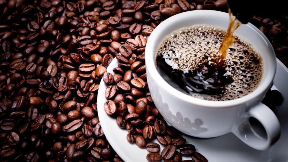 Mug on plate filled with coffee surrounded by coffee beans 