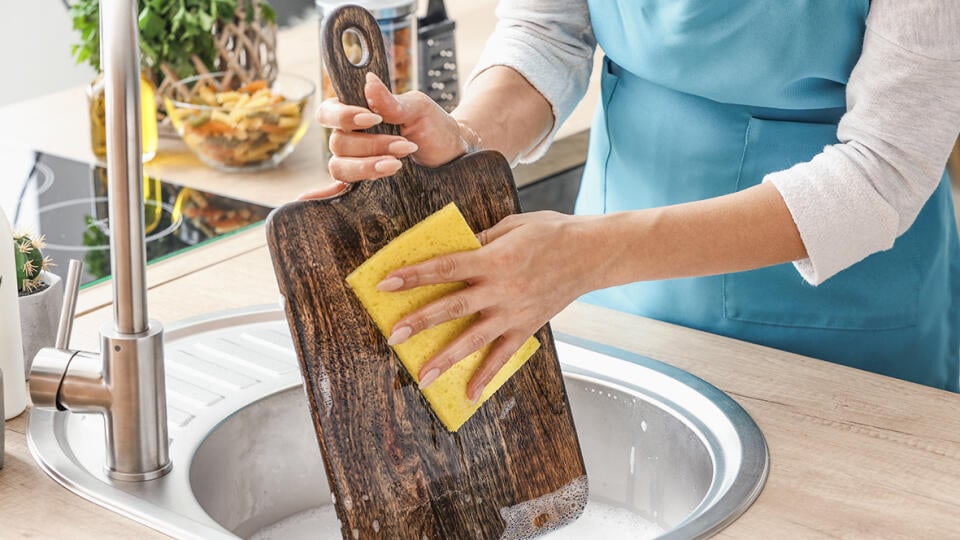 Woman,Washing,Wooden,Board,In,Kitchen,Sink