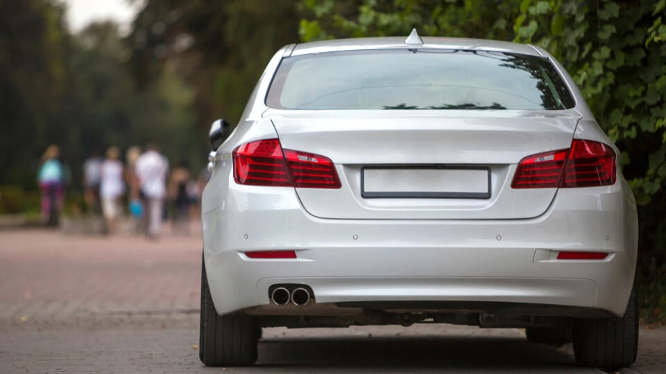 Back,View,Part,Of,White,Car,Parked,On,City,Pedestrian