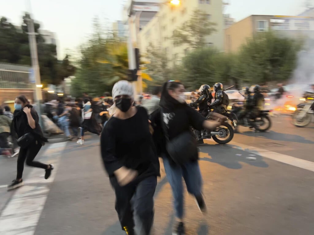 WA 37 Teherán - Na snímke z pondelka 19. septembra 2022 od osoby, ktorá nie je zamestnaná v agentúre Associated Press (AP), a ktorú získala agentúra AP mimo Iránu, ženy utekajú pred policajtmi počas protestu proti smrti mladej iránskej ženy Mahsá Amíníovej v centre Teheránu. Mravnostná polícia v Teheráne zatkla 22-ročnú Amíníovú za údajné porušenie pravidiel obliekania. Iránka po troch dňoch vo väzbe upadla do kómy a zomrela. Jej smrť vyvolala kritiku medzinárodných predstaviteľov aj protesty ve