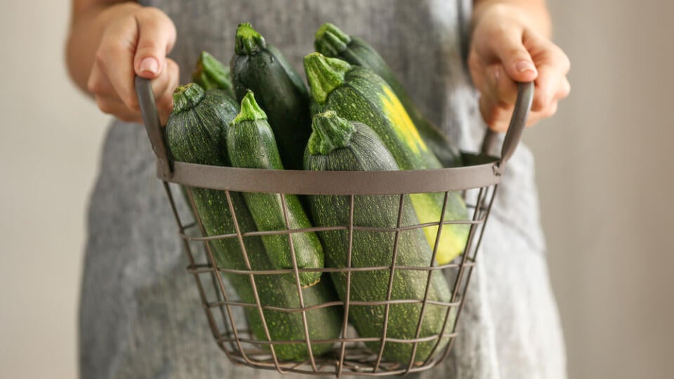 Woman,Holding,Basket,With,Fresh,Zucchini,,Closeup