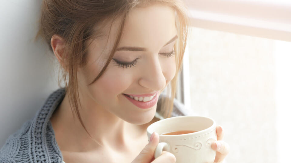 Beautiful,Young,Woman,Drinking,Tea,Near,Window,At,Home