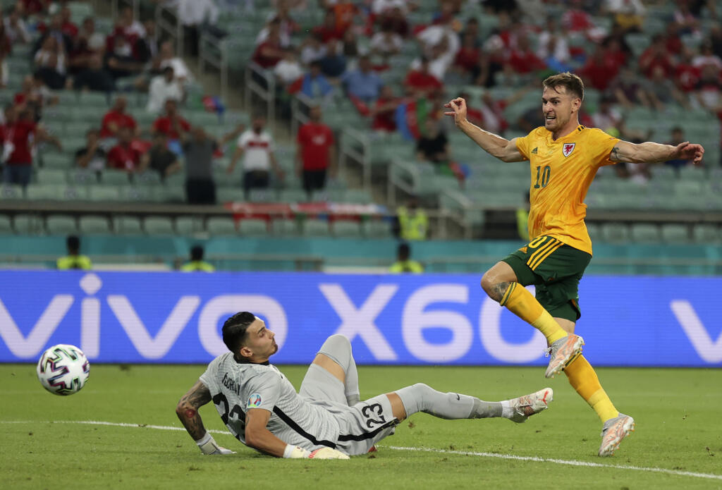 EBE 23 Baku - Na snímke vpravo waleský stredopoliar Aaron Ramsey strieľa úvodný gól v zápase A-skupiny na majstrovstvách Európy vo futbale Turecko – Wales v stredu 16. júna 2021 v azerbajdžanskom Baku. FOTO TASR/AP
Wales' Aaron Ramsey, right, scores his sides first goal past Turkey's goalkeeper Ugurcan Cakir during the Euro 2020 soccer championship group A match between Turkey and Wales the Baku Olympic Stadium in Baku, Azerbaijan, Wednesday, June 16, 2021. (Naomi Baker/Pool via AP)