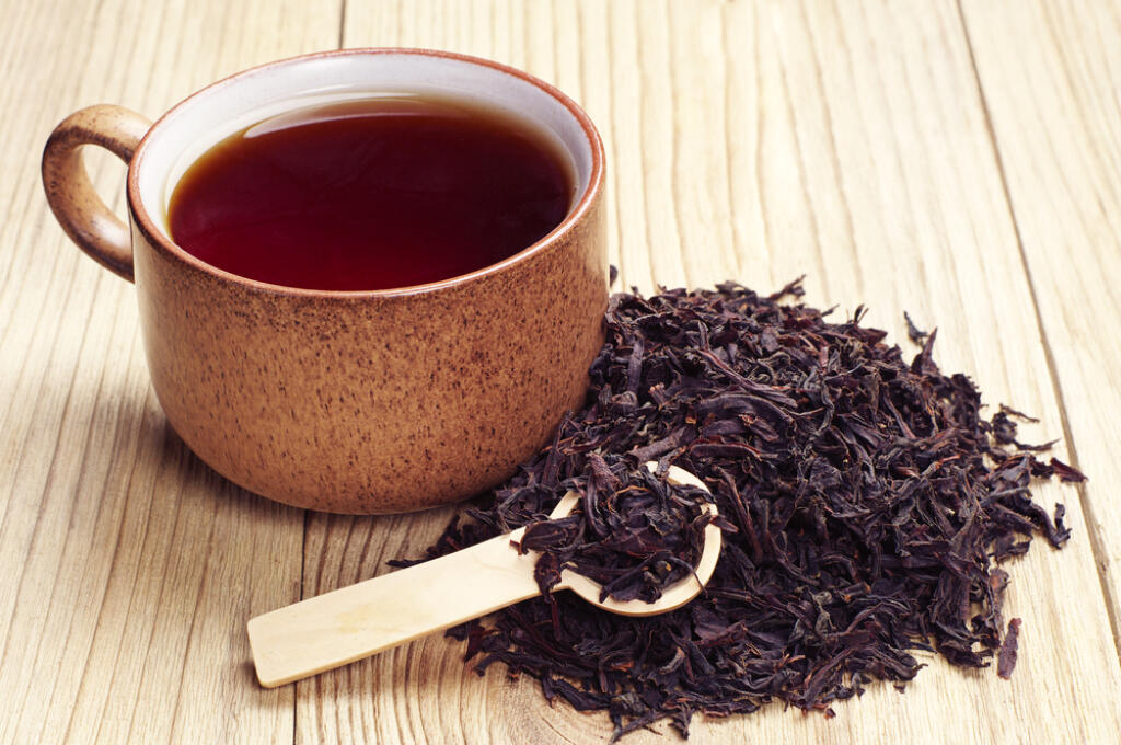 Black,Tea,In,A,Cup,And,Dried,Leaves,On,Wooden
