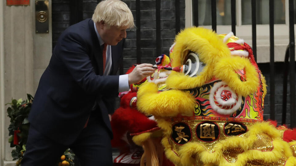 Britský premiér Boris Johnson dokresľuje oči na kostýme leva pred vystúpením umelcov v tradičných kostýmoch levov pri príležitosti osláv čínskeho lunárneho Nového roka pred sídlom na Downing Street 10 v Londýne.