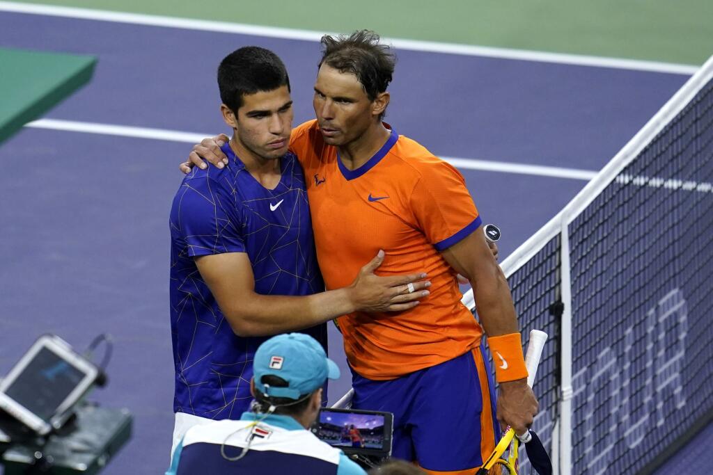 Na snímke vpravo španielsky tenista Rafael Nadal oslavuje postup do finále dvojhry na turnaji ATP Masters 1000 v Indian Wells, keď v semifinálovom stretnutí vyradil o 17 rokov mladšieho krajana Carlosa Alcaraza (vľavo).