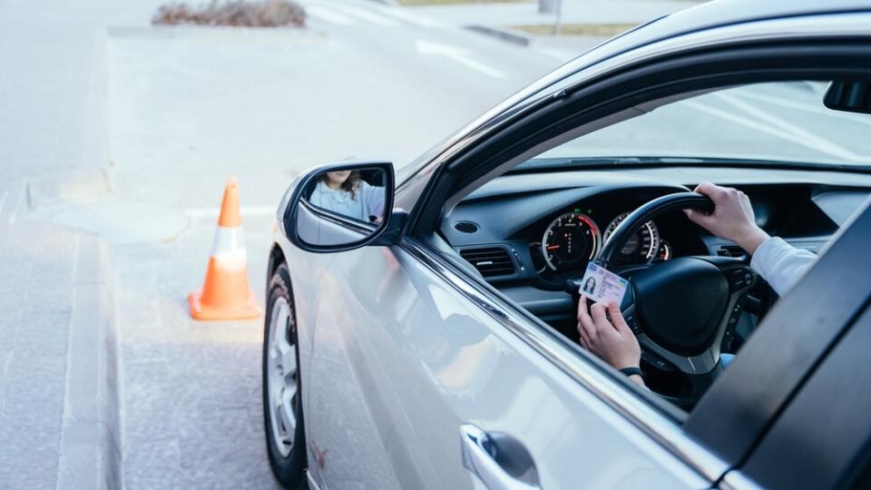 Close,Up,Of,Womand,Hands,On,Wheel,With,Driving,License.