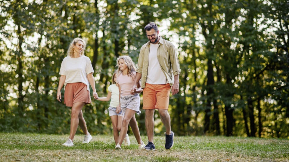 Portrait,Of,A,Happy,Family,Of,Four,Holding,Hands,And