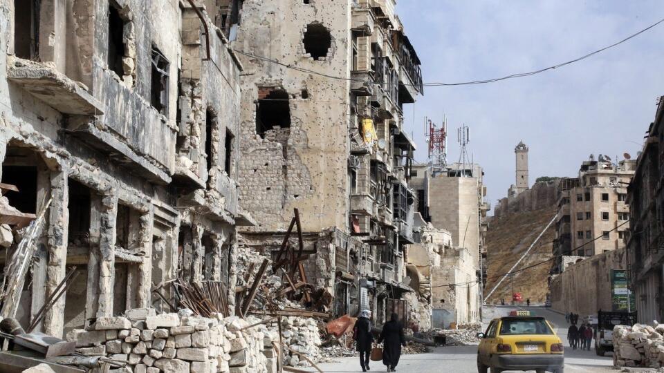 *** EXCLUSIVE *** JIBREEN, SYRIA - NOVEMBER 2017: 4 Nov 2017 East Aleppo. In the shadow of the citadel in Aleppo's Old City, merchants work to resurrect business in heavily damaged buildings ( where the stone is clean and white on building on left and people are crouching ). Award-winning photo-journalist Susan Schulman has captured the reality of Syrians trying to get back to normality in war-torn Aleppo. The American photographer travelled to the city in November 2017, almost a year afte