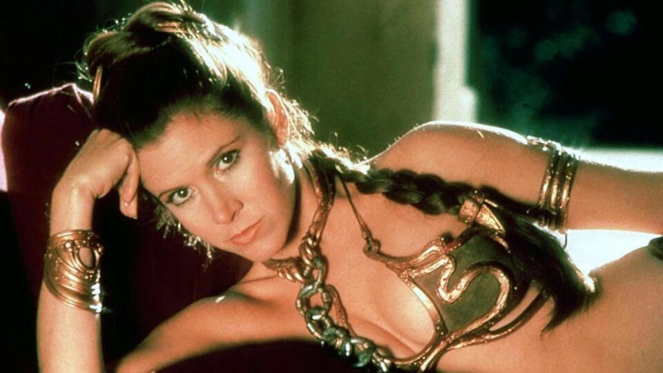 Carrie Fisher ako princezná Leia v „Hviezdne vojny: Epizóda VI – Návrat Jediho“ (1983) – na chvíľu zabudnite na mohutnú reťaz a skúste porozmýšľať, čo by ešte mohol byť signifikantný kúsok na Leile? Samotné zlaté bikiny asi nie, ale ich kombinácia s nápaditými zlatými doplnkami, mejkap do zlatista a hrubý zapletaný chvost siahajúci až po Lein pás, to už je o inom.  