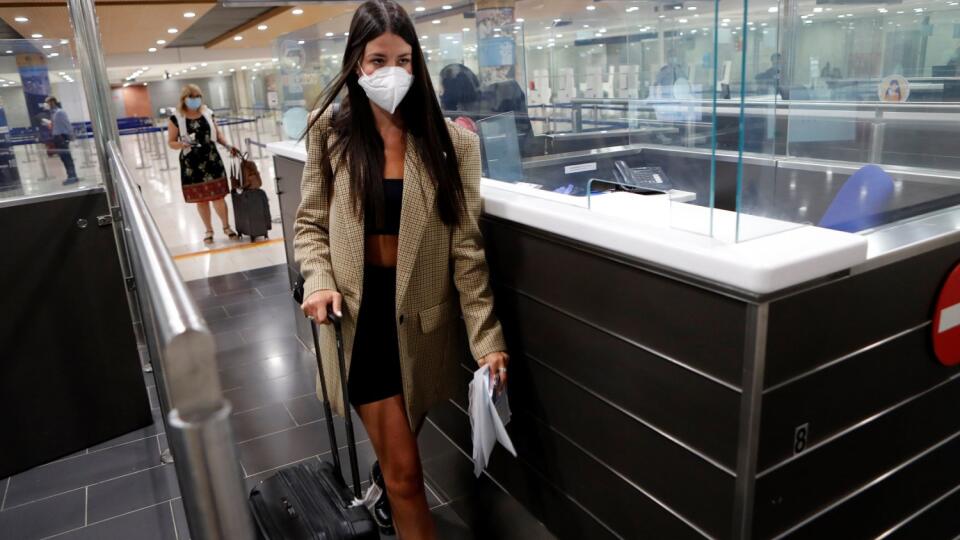 Pasažierka s ochranným rúškom na zabránenie šírenia nového koronavírusu kráča cez pasovú kontrolu po prílete na cyperské letisko v Larnake