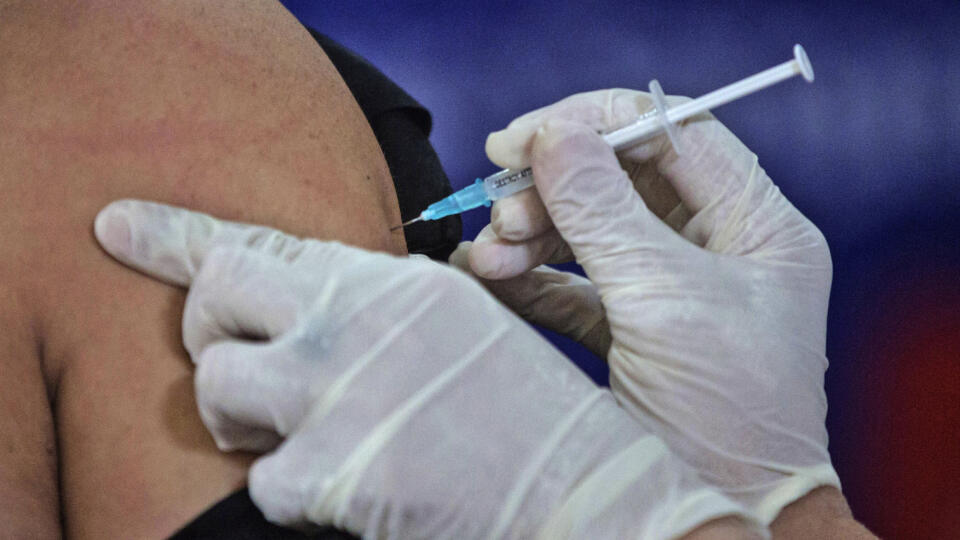 JB 41 Medan - Zdravotnícky pracovník dostáva vakcínu proti novému koronavírusu počas očkovania zdravotníkov v indonézskom meste Medan, na Severnej Sumatre 15. januára 2021. Indonézia pokračuje s hromadným očkovaním proti ochoreniu COVID-19 vakcínou CoronaVac od čínskej spoločnosti Sinovac Biotech. Indonézska vláda má pritom ambiciózny plán zaočkovať takmer 182 miliónov ľudí počas nasledujúcich 15 mesiacov. FOTO TASR/AP
A health worker gives a shot of COVID-19 vaccine to a government official i