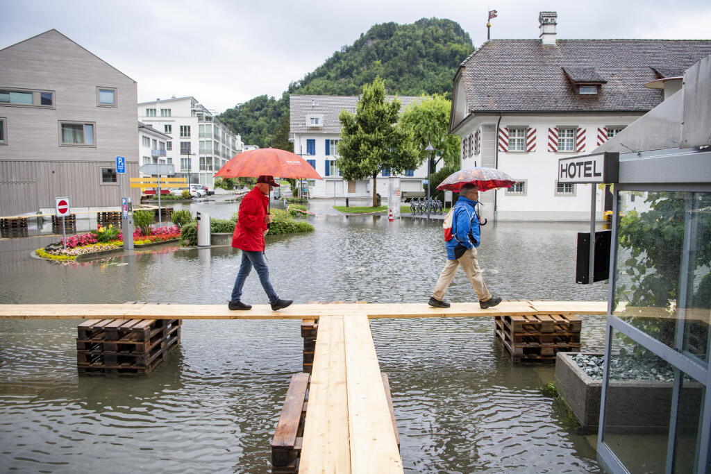 KK4 Stansstad - Na snímke ľudia kráčajú po lávke nad zaplavenou ulicou vo švajčiarskom meste Stannsad 15. júla 2021. FOTO TASR/AP
People walk on footbridges as the village square is covered with flood water in Stansstad at the Vierwaldstaettersee , Switzerland, Thursday, July 15, 2021. (Urs Flueeler/Keystone via AP)